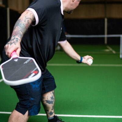 A player mid-swing during a pickleball game at Foxes Farm, Colchester