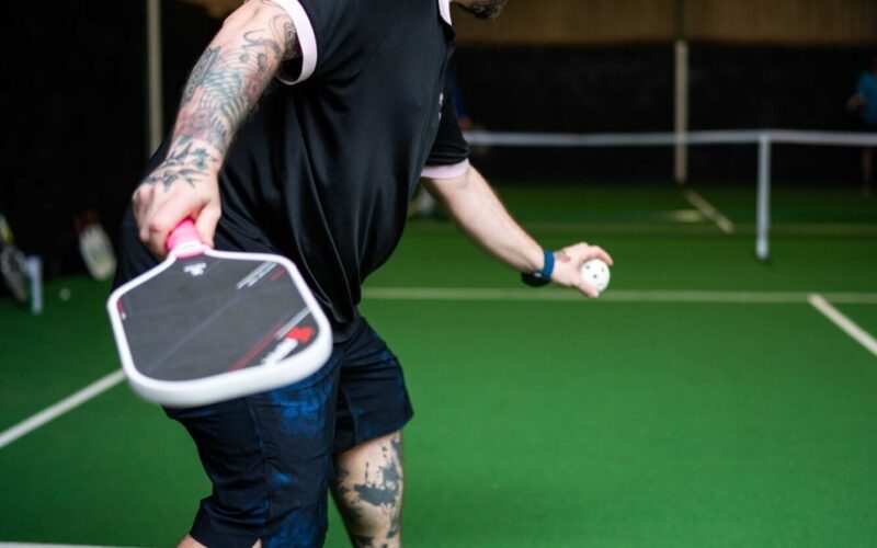 A player mid-swing during a pickleball game at Foxes Farm, Colchester