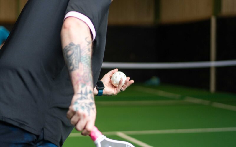 A player serving during a pickleball game at Foxes Farm, Essex