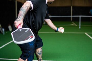 A player mid-swing during a pickleball game at Foxes Farm, Colchester