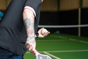A player serving during a pickleball game at Foxes Farm, Essex